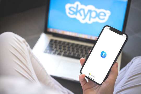 Kharkov, Ukraine - August 12, 2021: Skype app. Woman using smartphone with skype application. Brand logo photo
