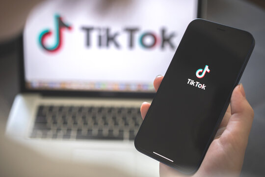 Kharkov, Ukraine - August 12, 2021: Tiktok social media app. Woman using smartphone with tiktok application. Brand logo photo