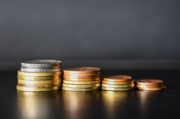 Towers of metal coins on a black background