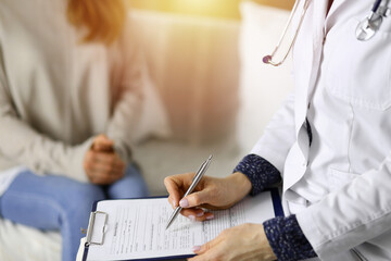 Close-up of woman-doctor and patient discussing current health examination while sitting indoors. Stay at home concept during Coronavirus pandemic and self isolation quarantine. Covid 2019