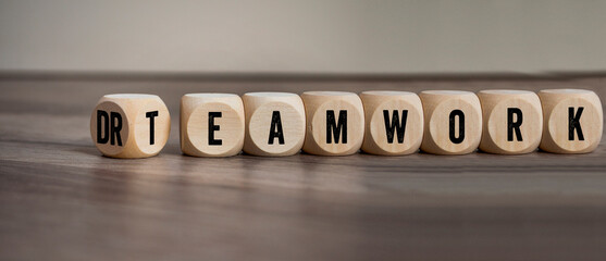 Cubes, dice or blocks with dreamwork and teamwork on wooden background