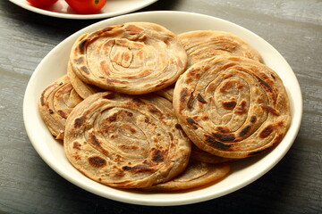 Healthy vegetarian food- homemade wheat paratha, porotta served with aloo paneer. street food style Indian cooking.