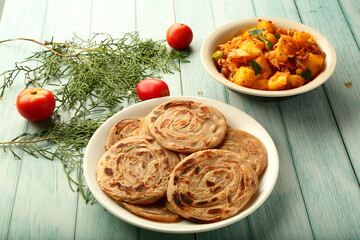 Indian vegan diet recipes- homemade wheat paratha served with potato curry roast.