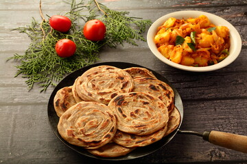 Indian food cuisine- healthy organic whole wheat paratha, porota  sertved with aloo paneer . vegetarian meal background.