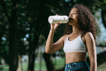 smiling athletic woman with a bottle of clean water.