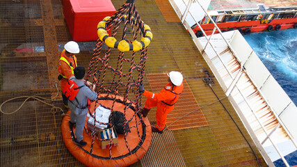 Workers are lifted by the crane to the offshore platform, Transfer crews by personal basket from the platform to crews boat.
