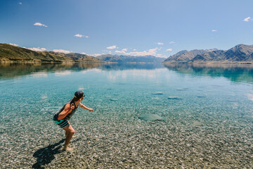 Fototapeta na wymiar Man skipping rocks in lake in New Zealand