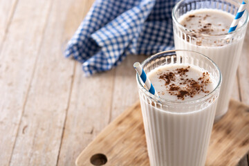 Fresh horchata with cinnamon in glass on rustic wooden table. Copy space