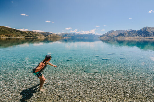 Man Skipping Rocks In Lake