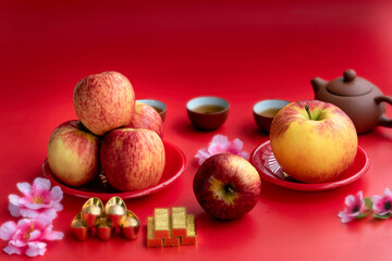 Red apple in red plate ,accessories on lunar new year & chinese new year vocation concept and flower on red background.