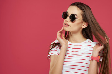 pretty woman wearing glasses striped tshirt styles posing pink background