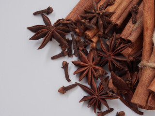 a stick of cinnamon and a star of anise spices are isolated on a white background close-up