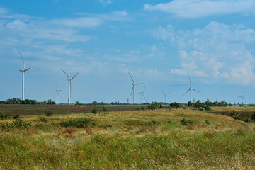 Panoramic view of wind farm with high wind turbines for generation electricity. Green energy concept. Windmills for electric power production. Energy production with clean and renewable energy