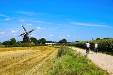 Beesel, Netherlands - July 9. 2021: View on cycling track with cyclists in rural dutch maas...