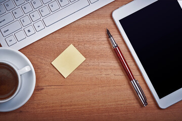 Wooden desk office with pc cayboard, tablet, and other work supplies with cup of coffee. Top view with copy space for input the text. Designer workspace on desk table essential elements on flat la