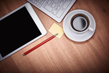 Wooden desk office with pc cayboard, tablet, and other work supplies with cup of coffee. Top view...
