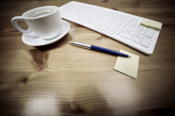 Wooden desk office with pc cayboard, and other work supplies with cup of coffee. Top view with copy space for input the text. Designer workspace on desk table essential elements on flat lay