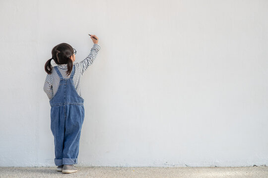 Little children painting on white wall