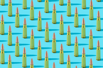 7.62mm AK-47 gold bullets in a row, patern with blue pastel background