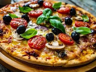 Circle pizza with mozzarella, white mushrooms, salami and tomatoes on wooden table
