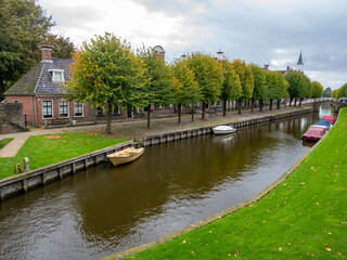 Rows of houses and trees on Lindengracht quay along canal in Sloten, Sleat, Friesland, Netherlands