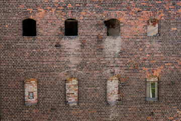 Destroyed windows in a brick wall nearby. Background.