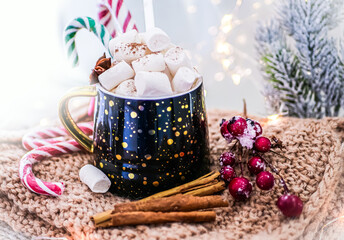 Fototapeta na wymiar Winter hot drink dark mug with hot chocolate with marshmallows and cinnamon, cane lollipops, New Year's decor. Cozy home atmosphere, festive mood. Christmas style, wood background