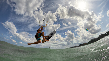 Kite surfer jumps with kiteboard in transition