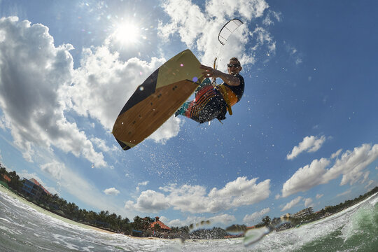 Kite surfer jumps with kiteboard in transition