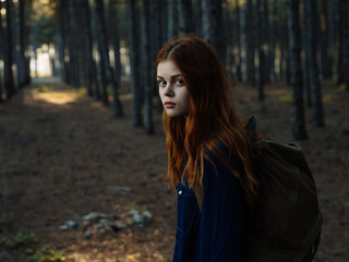 pretty woman in the forest with a backpack nature walk