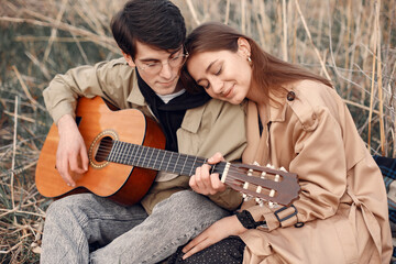 Beautiful couple spend time in a autumn field