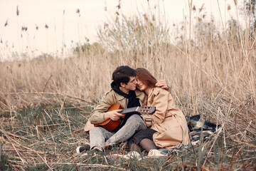Naklejka na ściany i meble Beautiful couple spend time in a autumn field