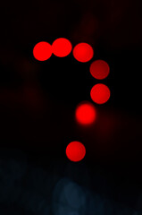 Question mark make with red light in abstract background.