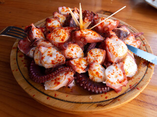 Galician-style octopus a traditional Galician dish served on the wooden plate © photohampster