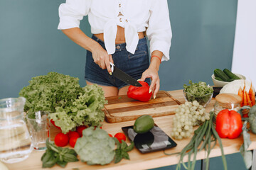 Beautiful and sporty girl in a kitchen with a vegetables