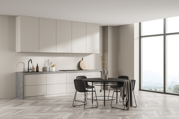 Fototapeta na wymiar Corner view of minimalist light beige kitchen with round black dining table