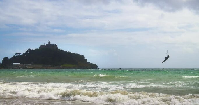 Big Waves Of The Ocean With Tourist Kitesurfing At Marazion, Saint Michael's Mount In Background - wide shot