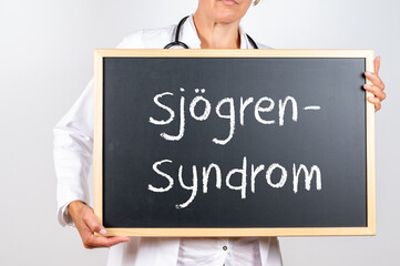 Ärztin mit einer Tafel zum Sjögren Syndrom einer Autoimmunerkrankung