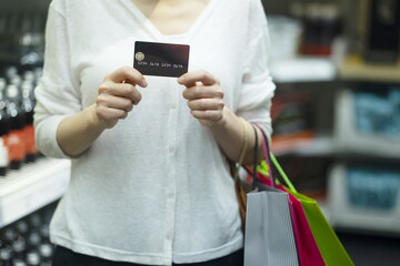 Woman holding shopping bags and credit card	