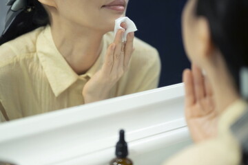 Woman cleaning face with cotton wool