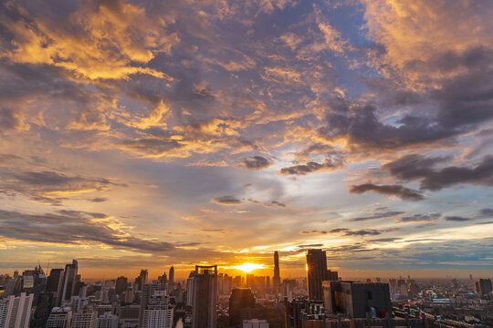 aerial view of beautiful cityscape at twilight with moving clouds, beautifully dramatic orange sky at sunset over city