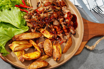 Barbecue or mala pork and mushrooms, bacon in a plate on a wooden cutting board