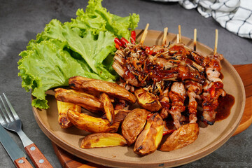 Barbecue or mala pork and mushrooms, bacon in a plate on a wooden cutting board