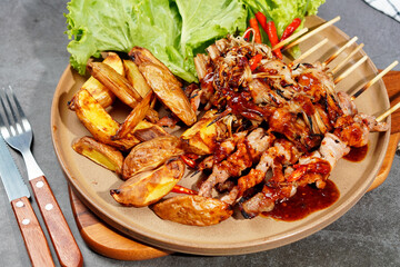 Barbecue or mala pork and mushrooms, bacon in a plate on a wooden cutting board