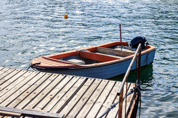 Small wooden boat moored next to wooden pier