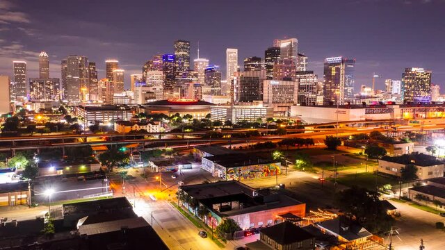 A time-lapse of the Houston skyline with cars speeding by in the foreground. 