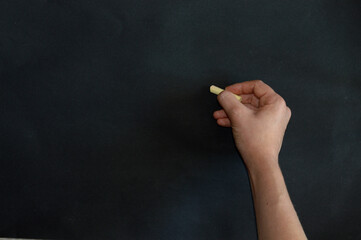 the child answers at the blackboard and writes something on it with chalk