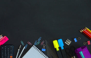school supplies on a black table. a large number of school subjects per academic year
