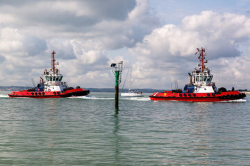 A pair of tug boats sailing into harbour