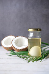 slice of fresh coconut and bottle of oil on a table 